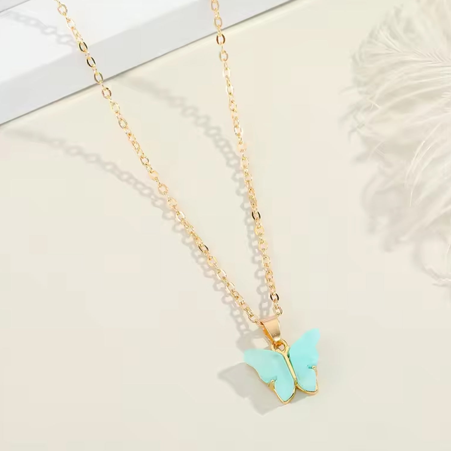 Assorted charm chain necklace with pink hearts and butterflies.