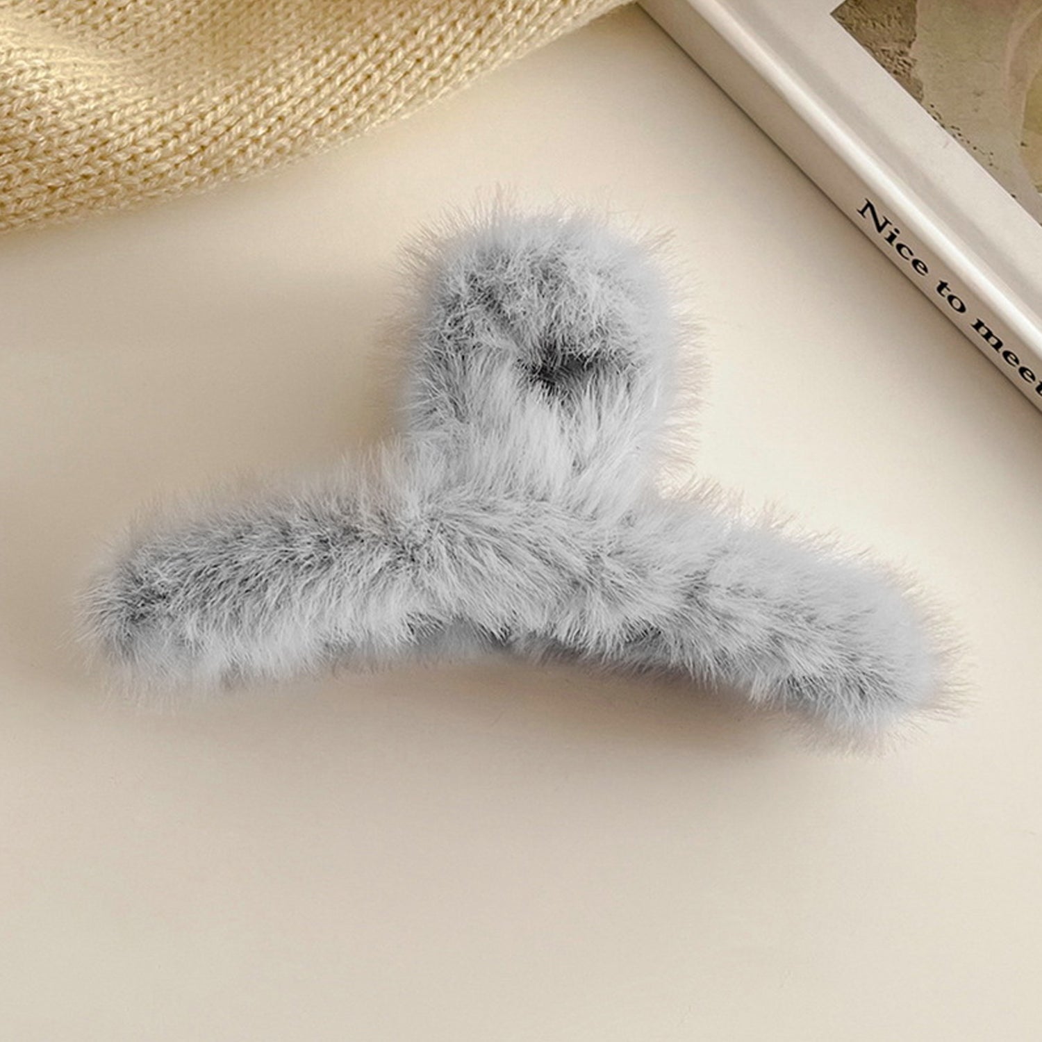 Model wearing a plush hair claw clip, demonstrating its comfortable and non-slip hold.
