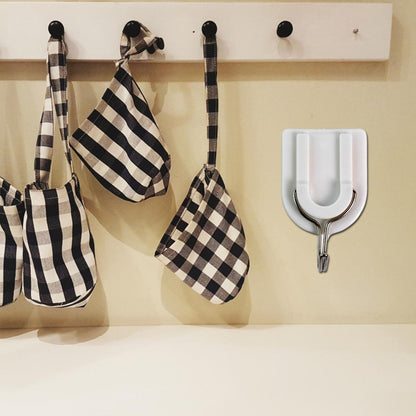Practical adhesive wall hook holding a small purse, demonstrating its versatile use.