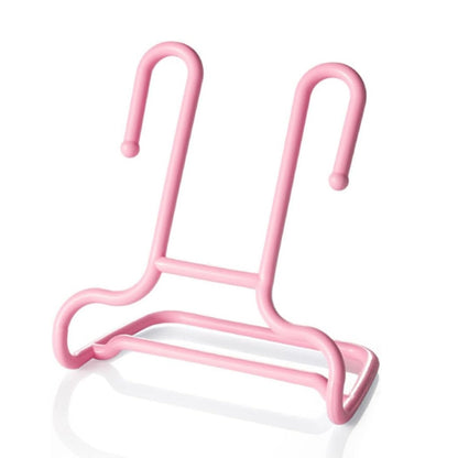 A single pink plastic shoe drying rack is shown against a plain white background with a subtle reflection.