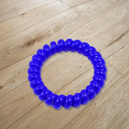 Close-up of a single purple telephone wire hair band showing its spiral design.