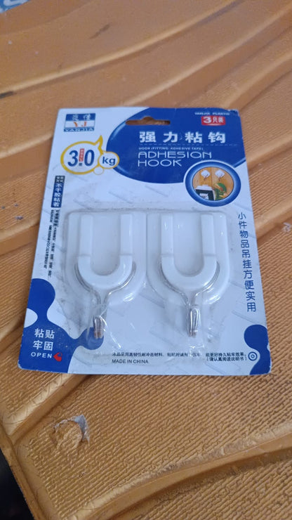 Multiple stainless steel adhesive hooks arranged on a wall, ready for various items.