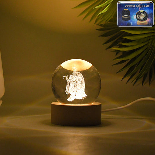 Radha Krishna 3D Crystal Lamp glowing on a wooden table.