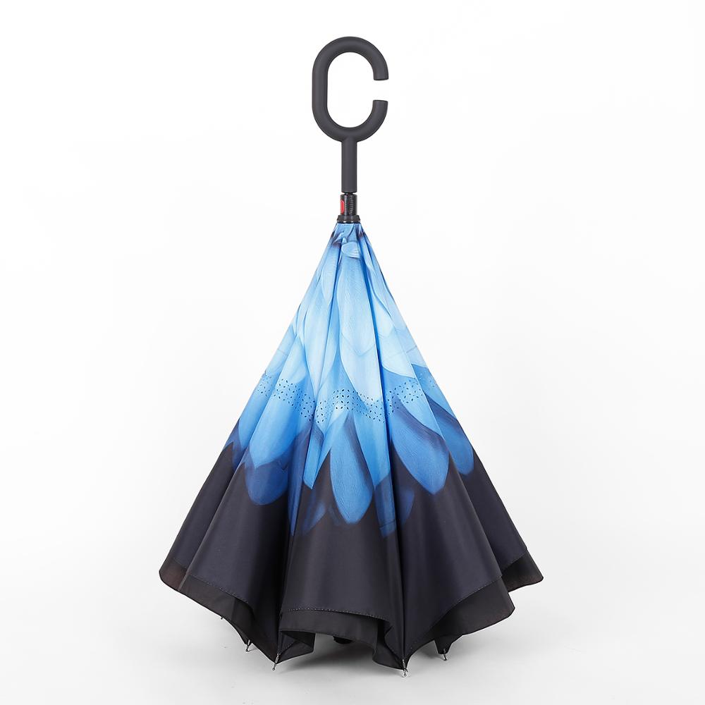 A closed reverse umbrella displays a gradient blue feather pattern, transitioning to black at the bottom.