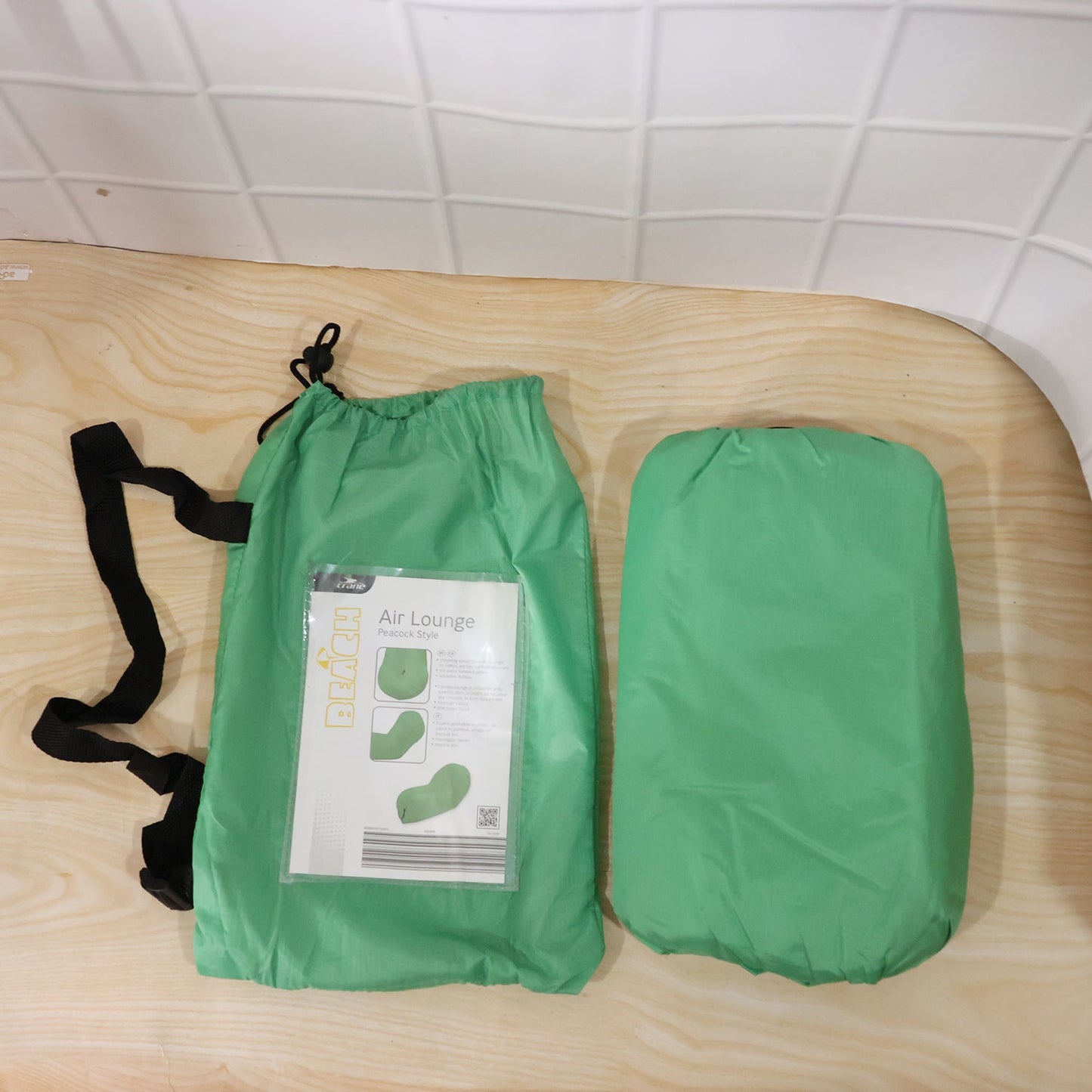 Person relaxing on inflatable green air sofa outdoors